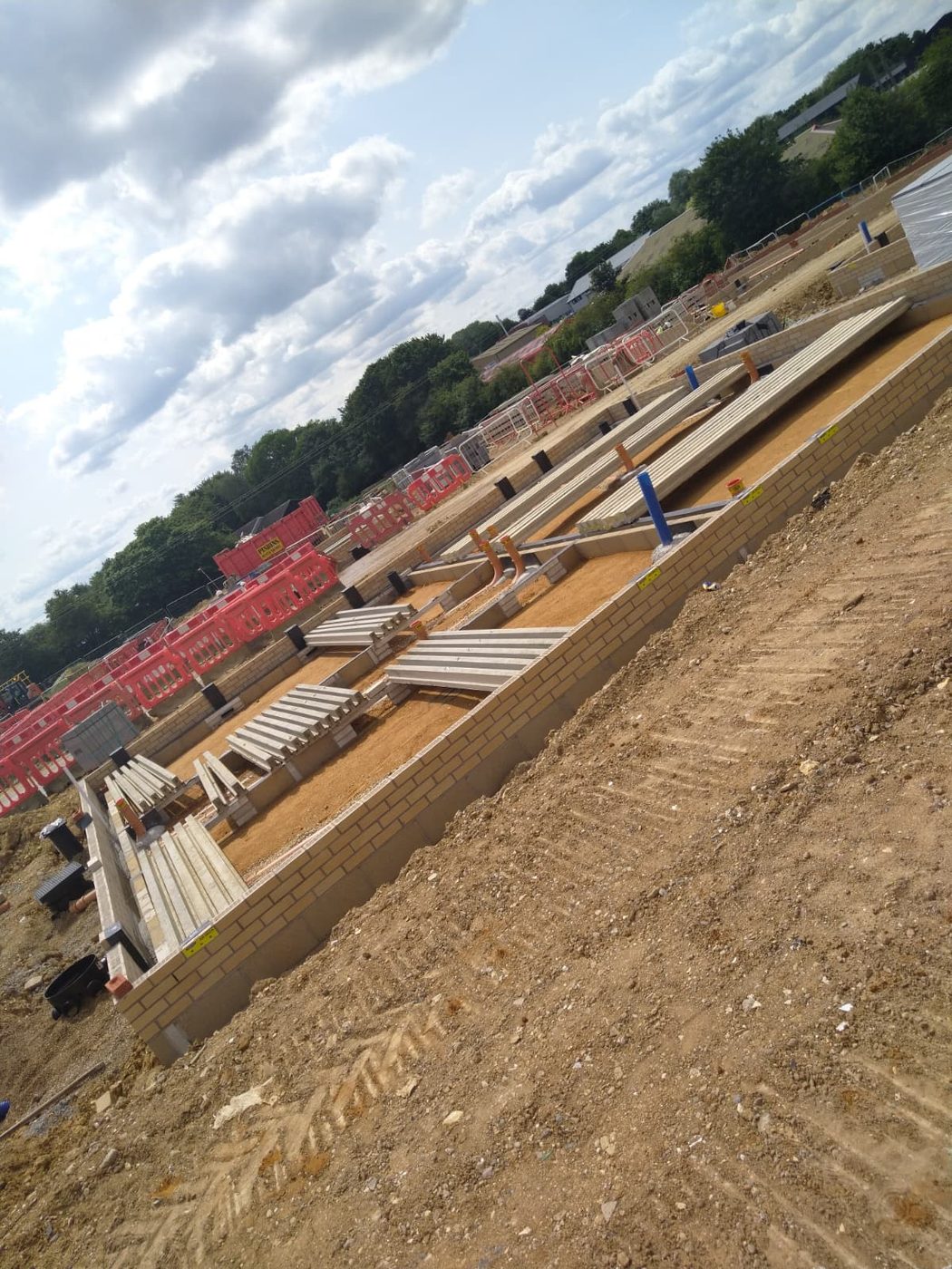 Materials stacked and the dug plot kept tidy through the build